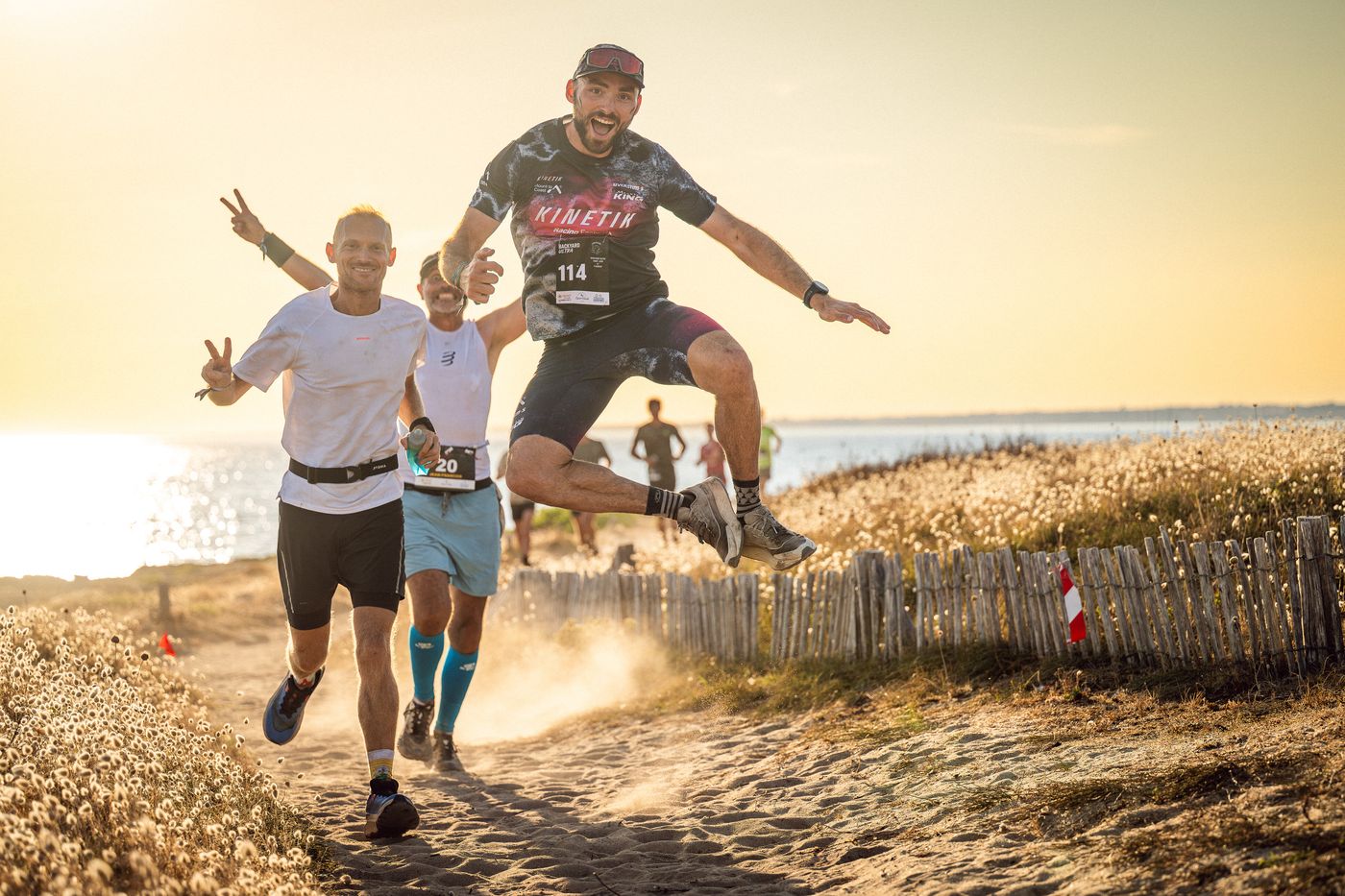 Coureurs sautant de joie sur les dunes pendant le Backyard Ultra Saint-Jude